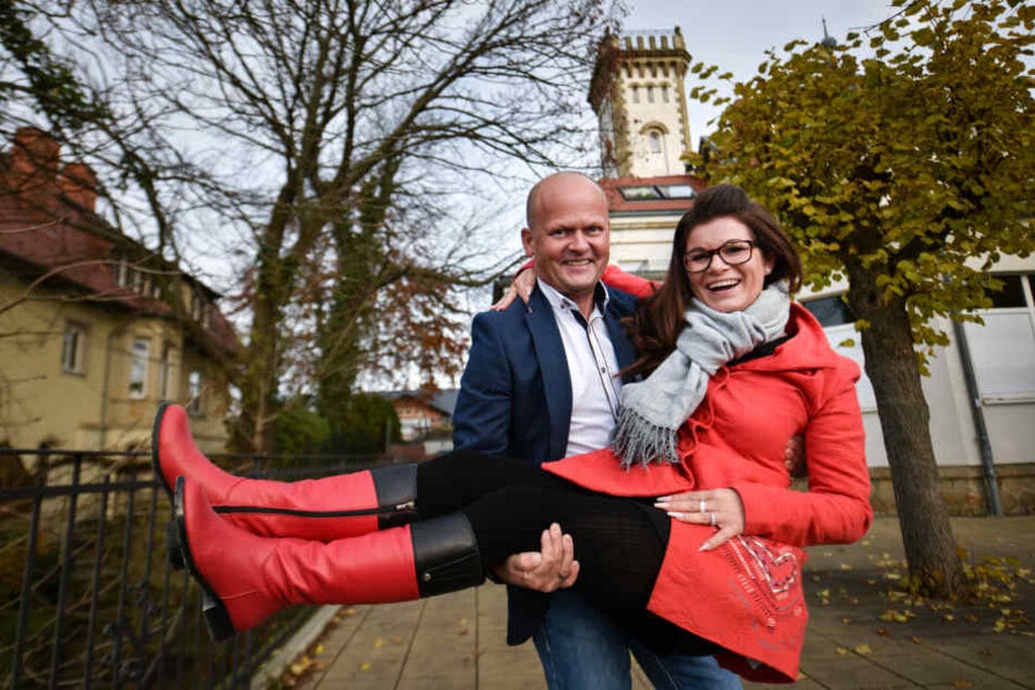 Carsten Rühle (48) trägt seine Frau Carolin (36) über die Schwelle seines künftigen Restaurants auf die Terrasse des Luisenhofs.