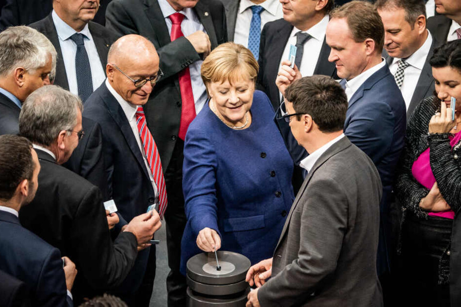 Bundeskanzlerin Angela Merkel, wirft bei der namentlichen Abstimmung zum Solidaritätszuschlag ihre Stimmkarte ein.