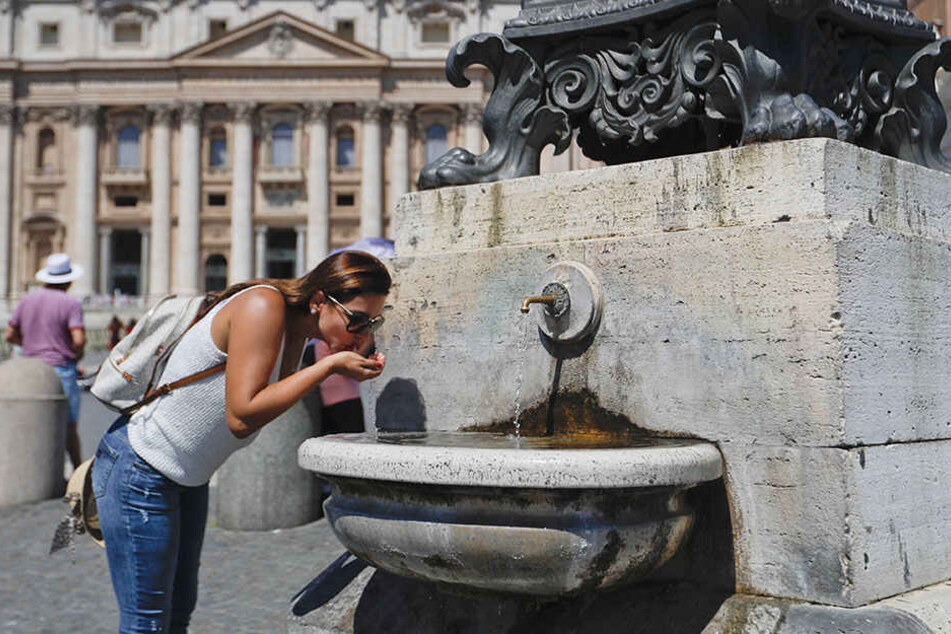 Auch in Rom war es heiß. Eine Touristin erfrischt sich an einem Trinkbrunnen.