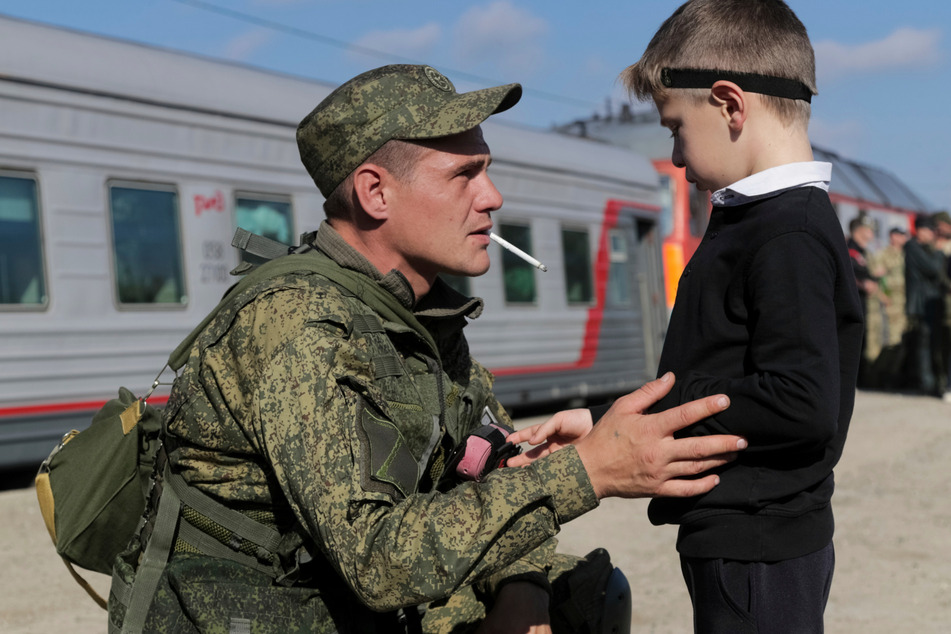 Ein russischer Rekrut verabschiedet sich von seinem Sohn, bevor er in einen Zug gen Kriegsgebiet steigt.