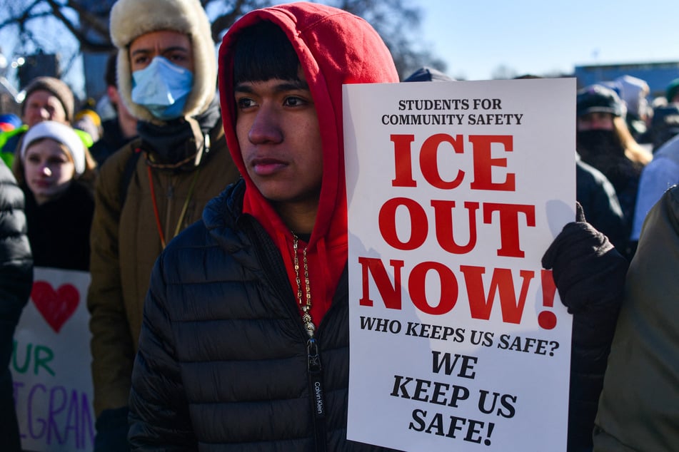 A high school student holds a sign reading "Who keeps us safe? We keep us safe!" during a protest against ICE outside the State Capitol in St. Paul, Minnesota, on January 14, 2026.