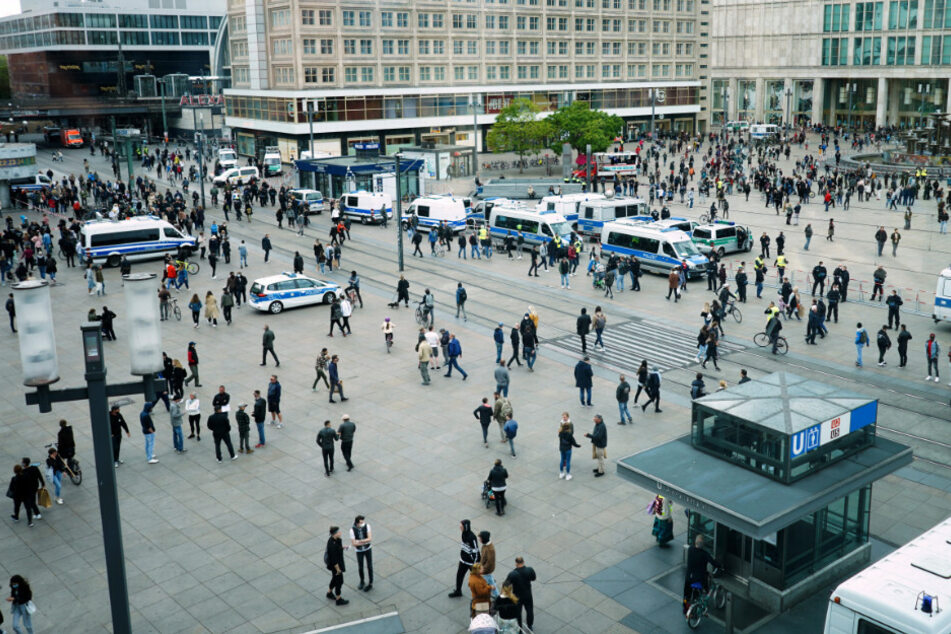 In kleineren Gruppen stehen Demonstranten auf dem Alexanderplatz zusammen.