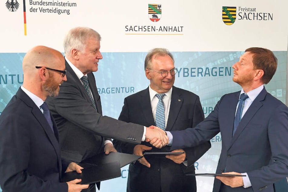 Verteidigungs-Staatssekretär Peter Tauber (CDU), Innenminister Horst Seehofer (CSU), Sachsen-Anhalts Ministerpräsident Reiner Haseloff (CDU) und Sachsens Regierungs-Chef Michael Kretschmer (CDU, v.l.n.r.) besiegeln per Handschlag die Ansiedlung.