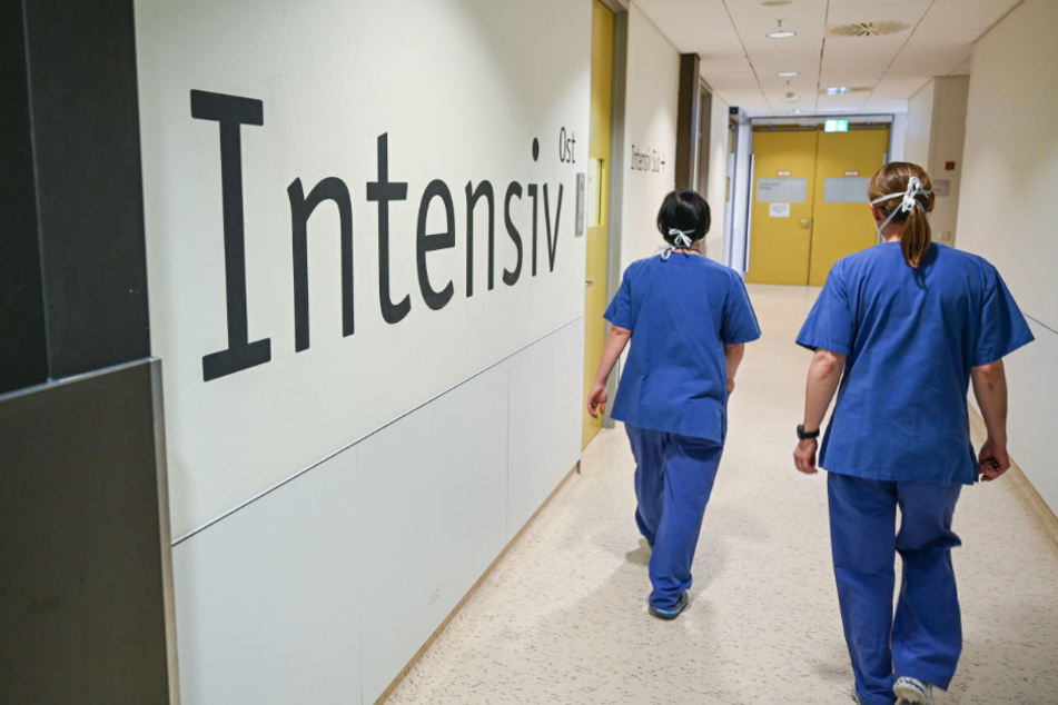 Zwei Pflegerinnen gehen an dem Schriftzug "Intensiv" vorbei.