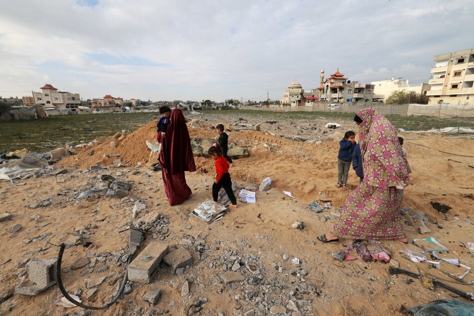 Palestinians inspect the destruction in Rafah on February 18, 2024, following overnight Israeli air strikes on the southern Gaza Strip border city.