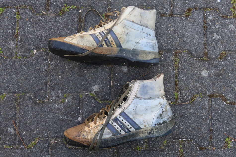 Ein Paar relativ gut erhaltene Turnschuhe liegt auf dem Boden - Taucher haben es bei Skelettteilen im Starnberger See gefunden.