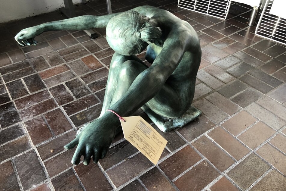 Die im Wald entdeckte Statue stellt einen Akt einer sitzenden Frau mit ausgestreckten Armen dar.