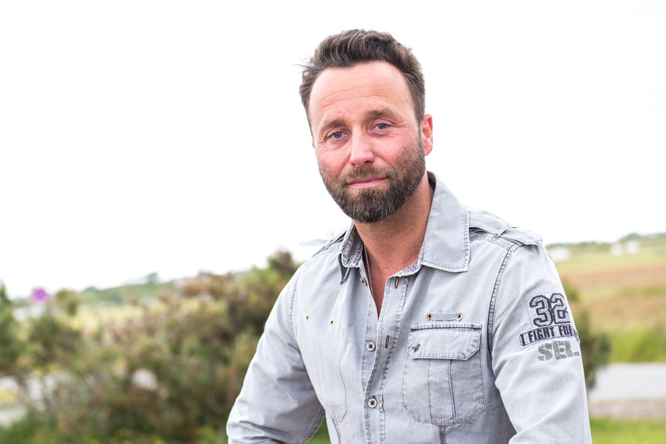 Der Sylter Dirk Lins (44) lächelt auf der Nordseeinsel im Ort Westerland. Lins unterstützt nebenbei Film- und Fernsehproduktionen als Location-Scout und sogenannter Runner auf seiner Heimatinsel.