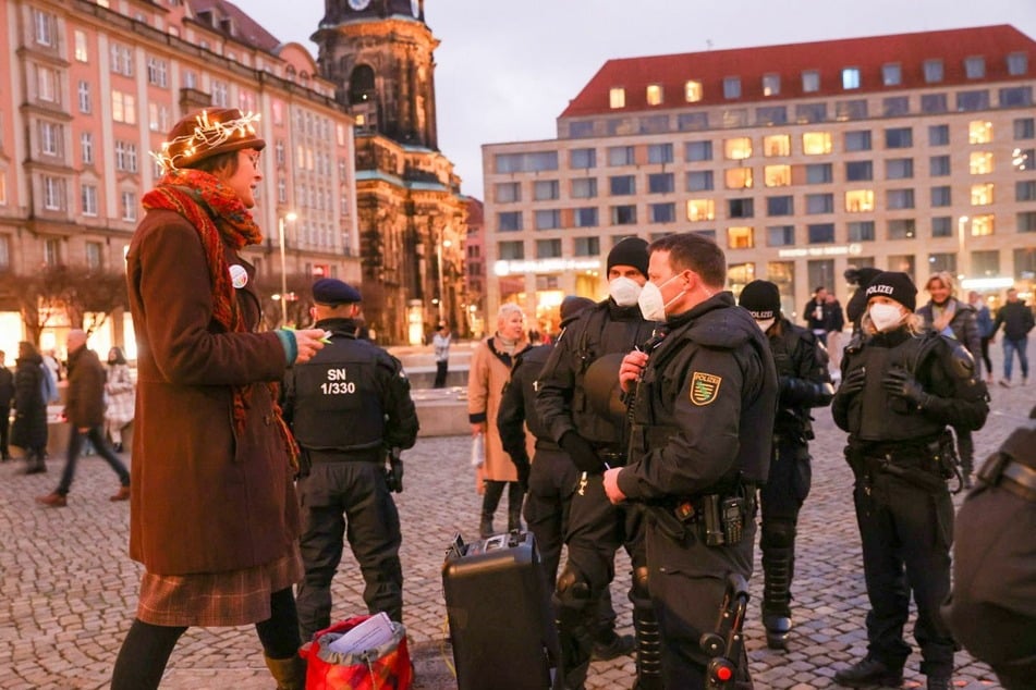 Polizisten im Gespräch mit einer Protest-Teilnehmerin.