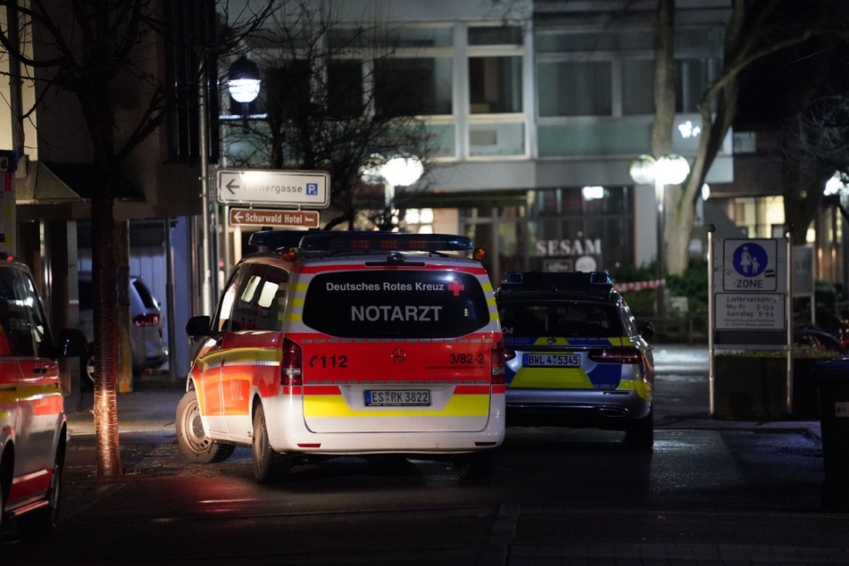 Fahrzeuge von Polizei und Rotem Kreuz stehen in der Nähe des Tatorts.