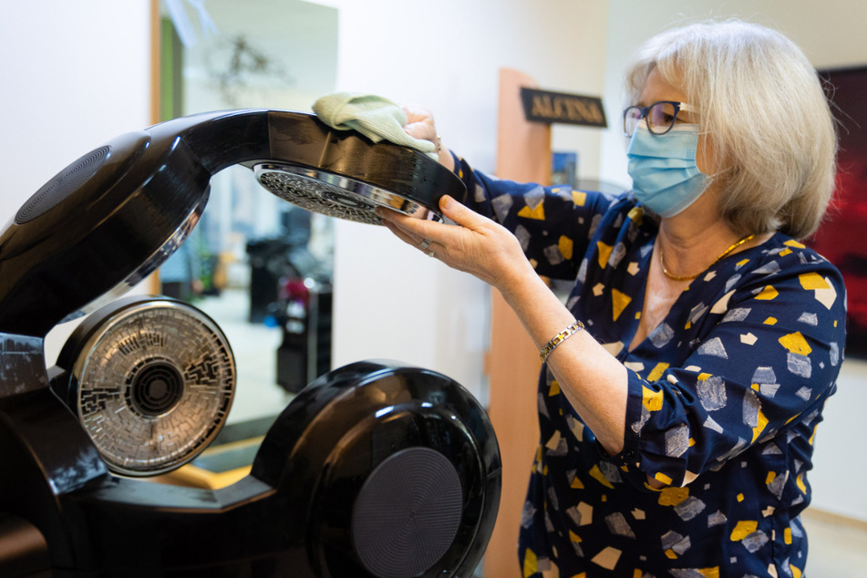 Die Friseumeisterin und Besitzerin des Friseursalon "Extra Locke" in Schweinfurt, Margit Rosentritt, reinigt einen sogenannten "Hairmaster".