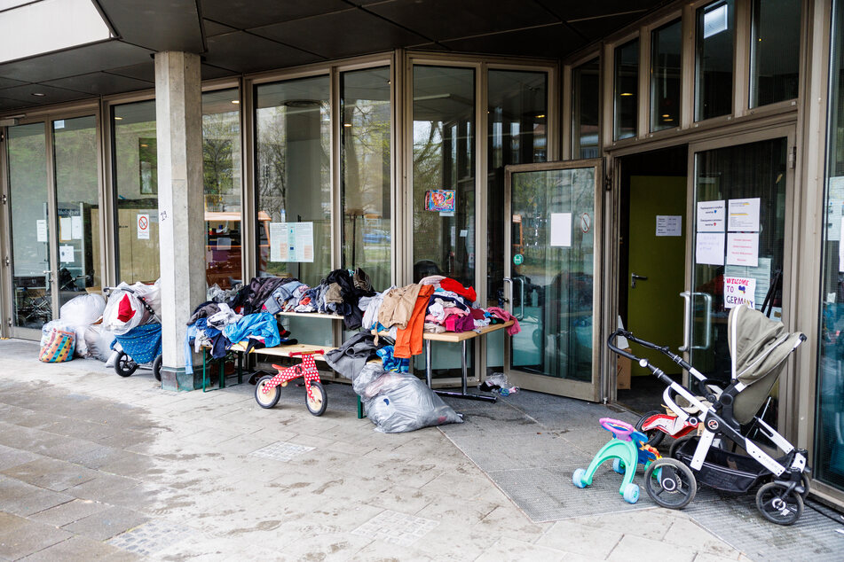 Ein Laufrad und zahlreiche Kleidungsstücke sind vor einer Flüchtlings-Notunterkunft in München zu sehen. Künftig können auch Gewerbeflächen als Unterkünfte genutzt werden.