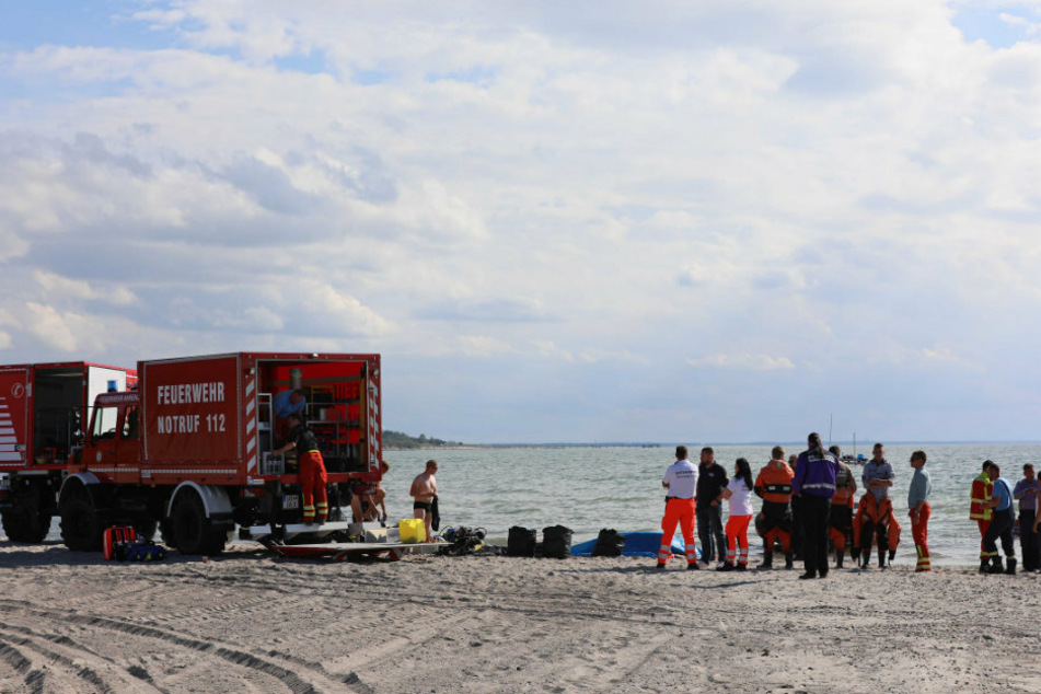 Einsatzkräfte stehen am Strand von Ahrenshoop.