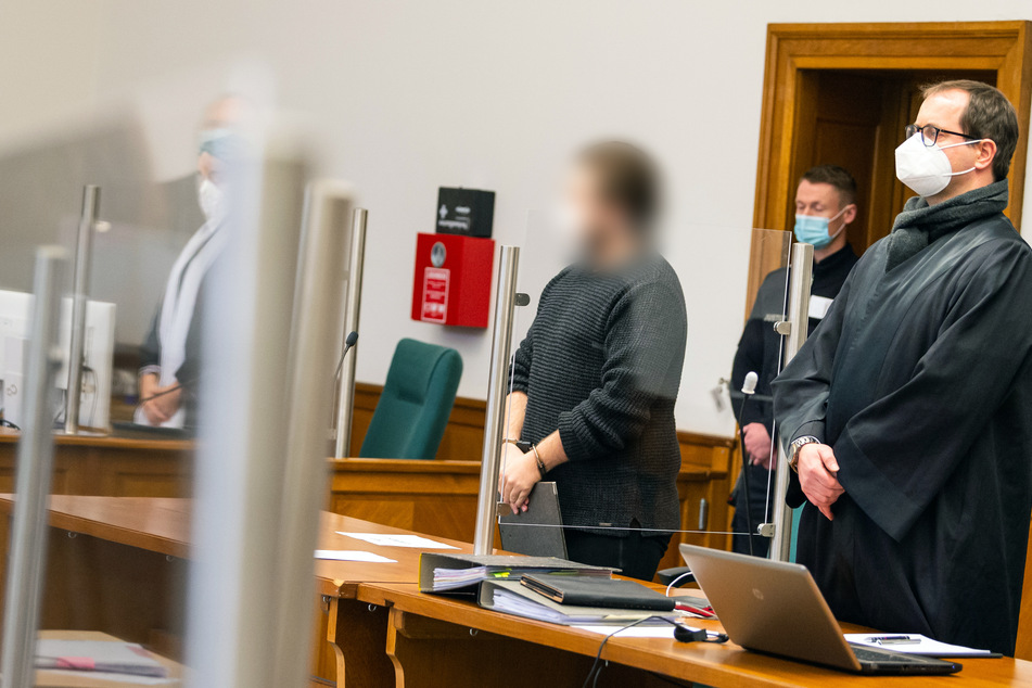 Der Angeklagte (l.) steht neben seinem Verteidiger Daniel Zimmermann (r.) im Landgericht. Der 20-Jährige soll im Juni 2020 in Neuenkirchen zwei Menschen getötet haben.