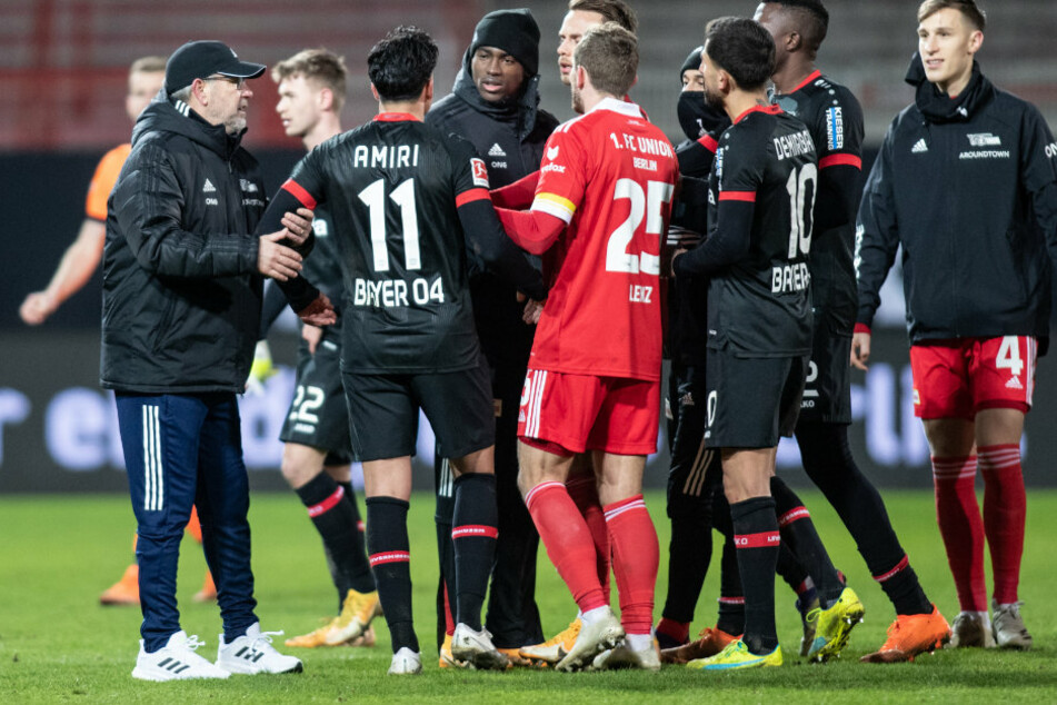 Unions Trainer Urs Fischer (54, l.) und Christopher Lenz (26, 4.v.l.) halten Nadiem Amiri (24, 2.v.l) von Bayer Leverkusen am Arm.