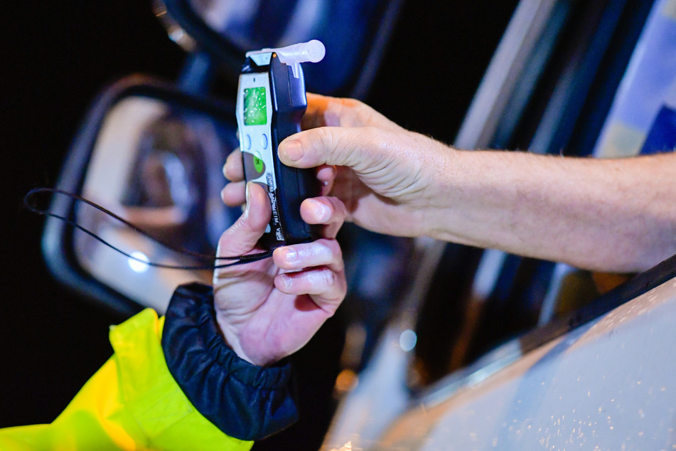 Sinsheim: Polizisten reichen bei einer präventiven Alkoholkontrolle bei Fahrern von Lastkraftwagen ein Alkoholmessgerät in eine Fahrerkabine.