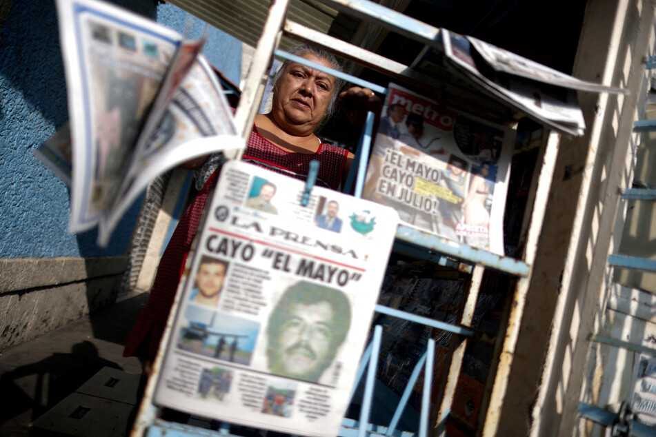 A seller arranges newspapers reporting the El Paso, Texas, arrest of Mexican drug lord Ismael "El Mayo" Zambada and Joaquin Guzman Lopez.