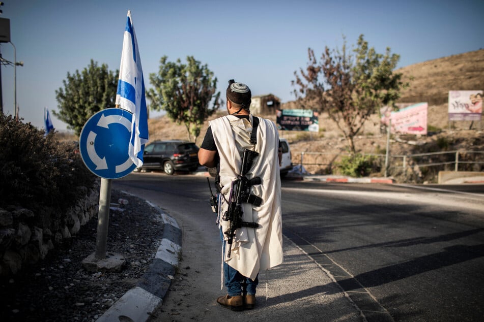 Ein israelischer Siedler trägt eine Waffe am Haupteingang der palästinensischen Stadt Nablus im nördlichen Westjordanland.