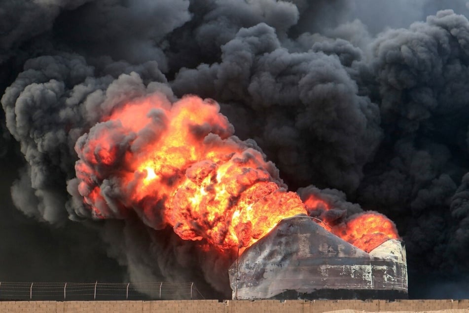 Thick smoke billows from a raging fire at oil storage tanks a day after Israeli strikes on Yemen's port of Hodeida on July 21, 2024.