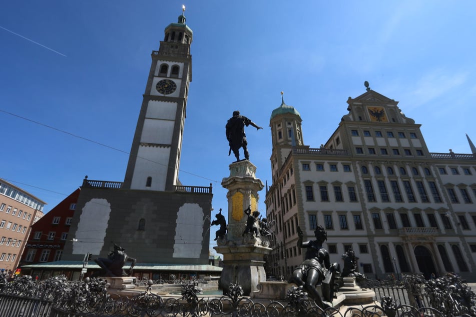 Bekanntes Stadtbild: Der Brunnen mit der Figur des römischen Kaisers Augustus zwischen dem besagten Perlachturm (l.) und dem Rathaus.