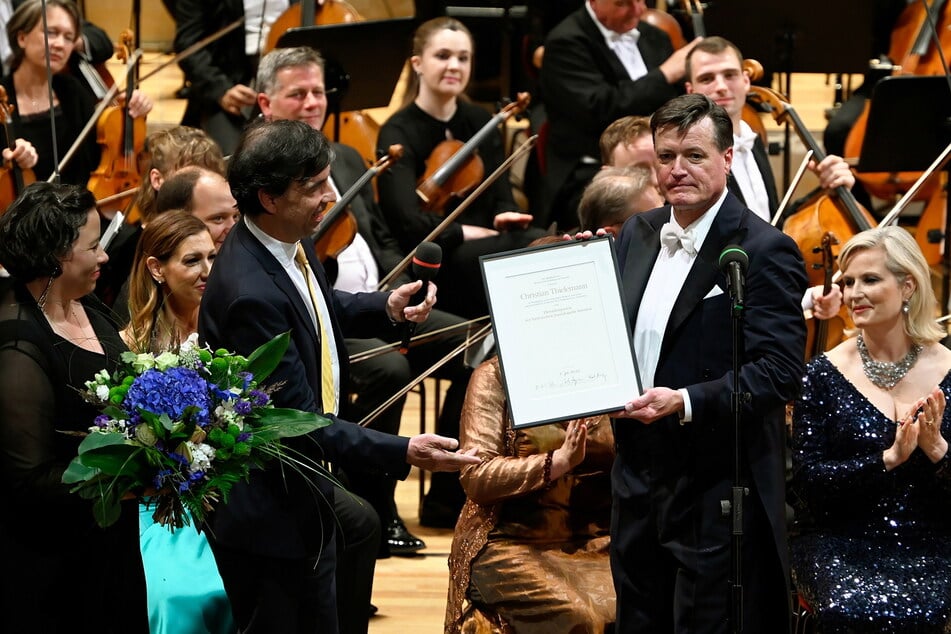 Christian Thielemann (65) nimmt die Urkunde über die Ehrendirigentschaft entgegen.