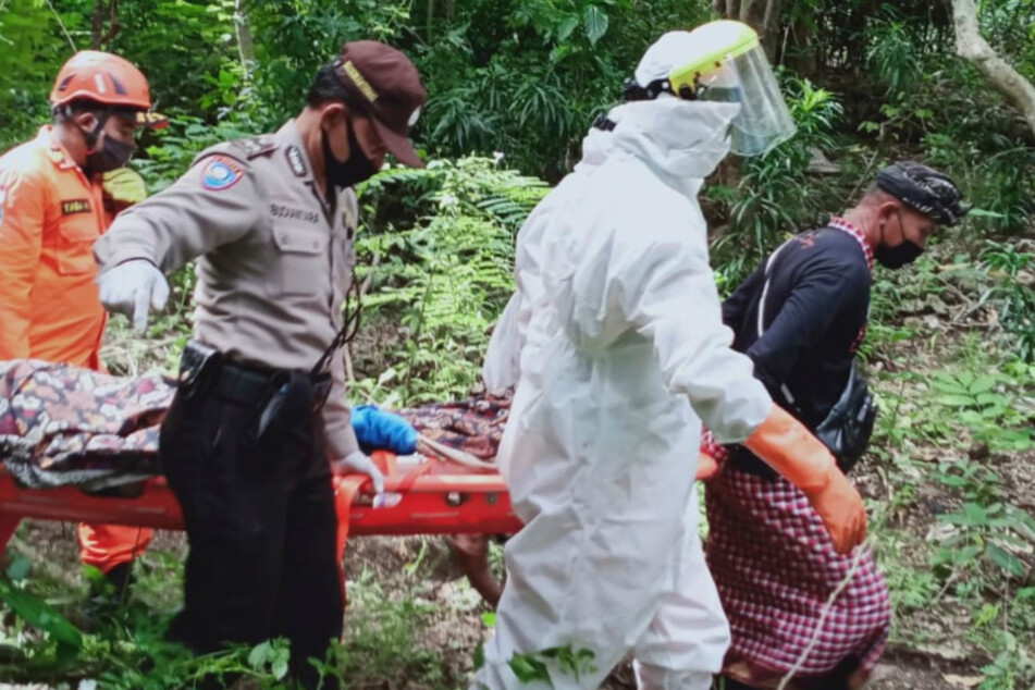 Rettungskräfte tragen den Tourist auf einer Bahre.