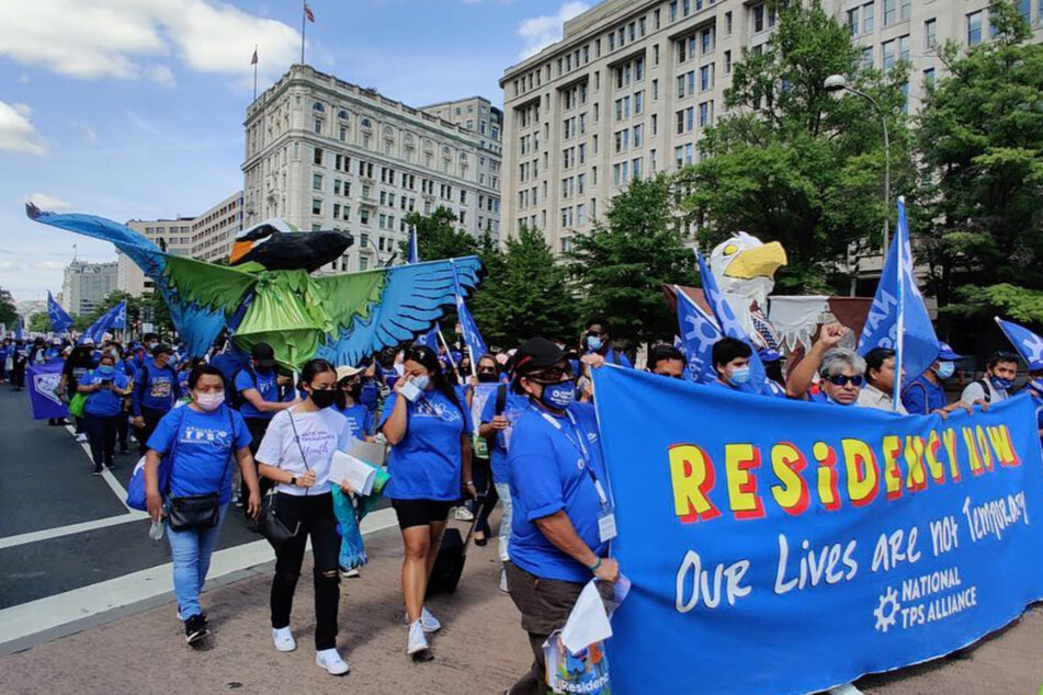 Members and supporters of the National TPS Alliance march for residency protections in Washington DC.