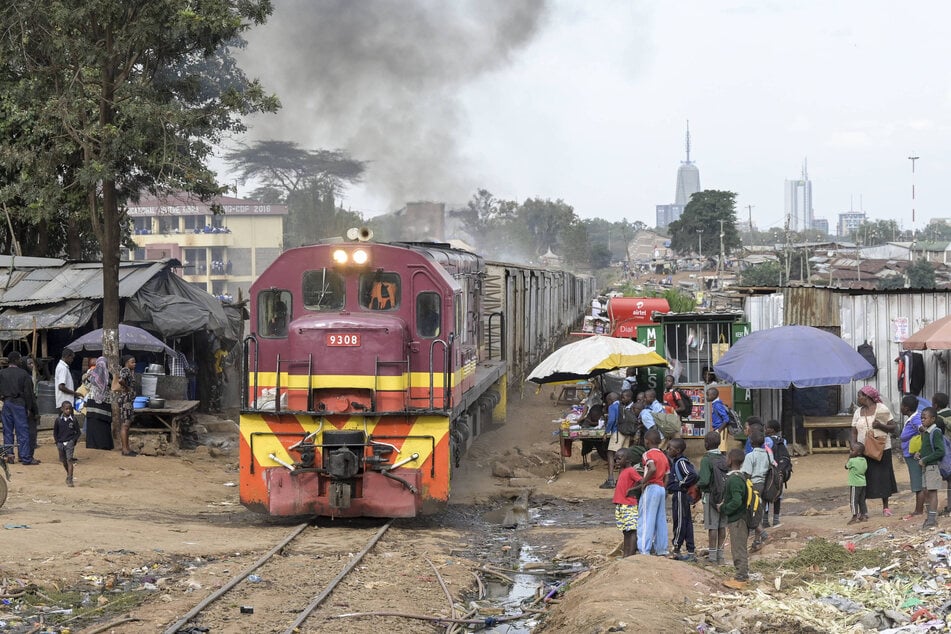 "Bitterarme Verhältnisse": Ein Güterzug fährt durch einen Slum von Nairobi - im Hintergrund die Wolkenkratzer der Hauptstadt Kenias.
