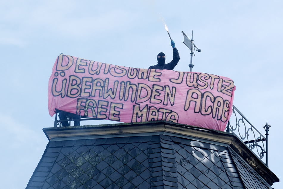 Während der Demo wurde ein Transparent auf dem Dach eines Hauses an der Wolfgang-Heinze-Straße ausgebreitet und Pyrotechnik gezündet.