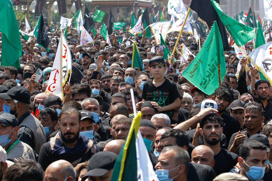 Gläubige versammeln sich nur teilweise mit Mundschutz ausgerüstet während einer Zeremonie am Tages der Aschura vor dem heiligen Schrein des Imam Hussein.