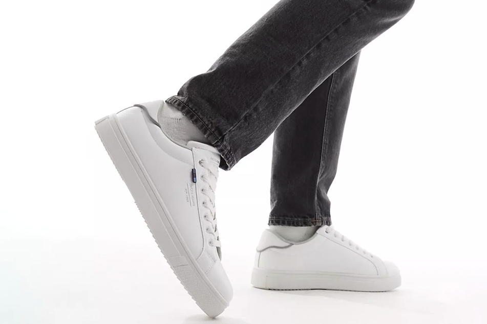 Weiße Sneaker passen hervorragend zur hellen Jeansjacke und bilden eine stylische Einheit.