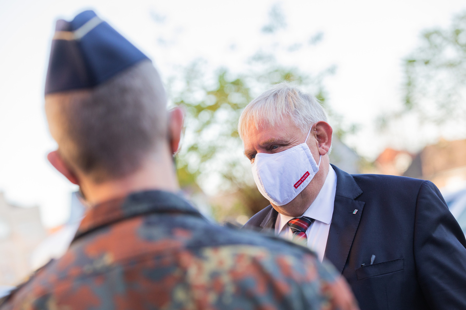 Karl-Josef Laumann (CDU, r), Gesundheitsminister von Nordrhein-Westfalen, spricht bei einem Besuch im Gesundheitsamt mit Soldatinnen und Soldaten der Bundeswehr.