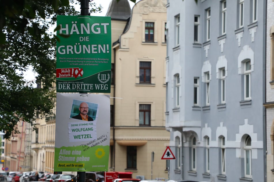 Ein umstrittenes Wahlplakat der Splitterpartei "III. Weg" hängt in Zwickau über einem Plakat der Grünen.