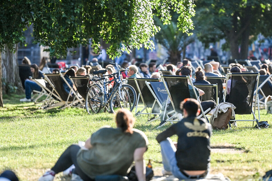 Menschen sitzen auf Liegestühlen und auf der Wiese. In Thüringen stecken sich aktuell vor allen jüngere Menschen mit dem Coronavirus an. (Symbolbild)