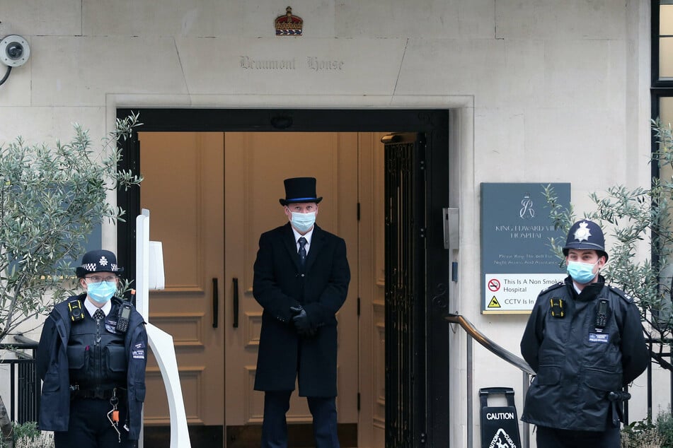 Police officers and a gatekeeper stand outside King Edward VII's Hospital where Britain's Prince Philip is being treated.