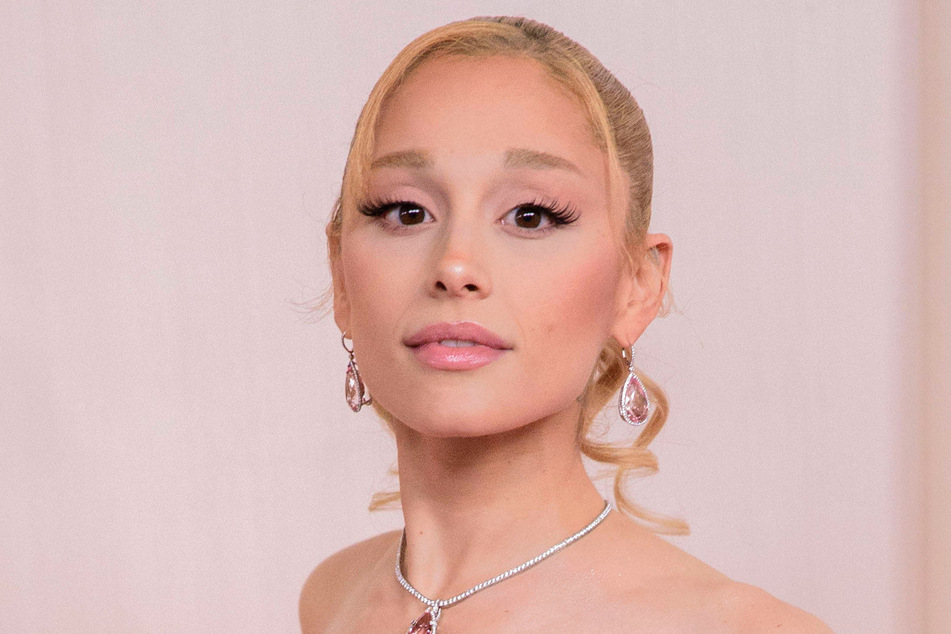 Ariana Grande wowed in a pastel pink Versace dress for her latest Glinda-inspired fashion moment.