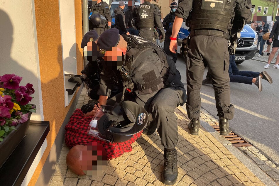 Bei einer unangemeldeten Corona-Demo in Zwönitz (Erzgebirge) kam es zu Ausschreitungen. Mehrere Polizisten wurden verletzt, mussten anschließend einen Mann zu Boden drücken.