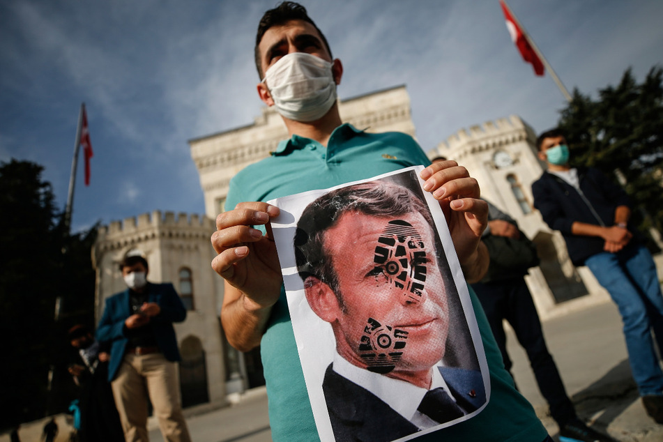 Protest in Istanbul: Ein Jugendlicher hält ein mit einem Schuhabdruck versehenes Foto von Emmanuel Macron (42), Präsident von Frankreich.