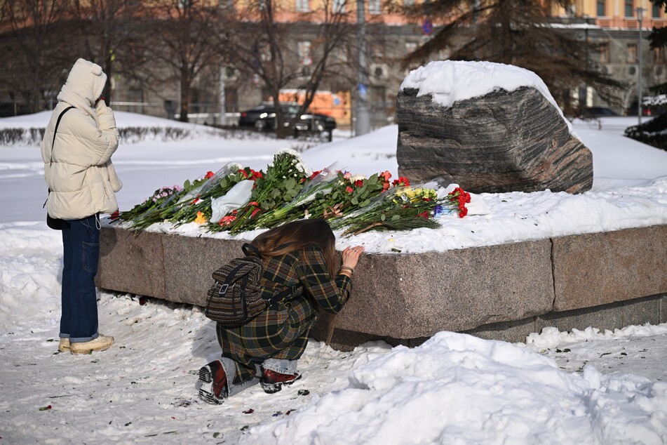 People come to lay flowers for late Russian opposition leader Alexei Navalny at the Solovetsky Stone, a monument to political repression that has become one of the sites of tributes for Navalny, in Moscow on Tuesday.