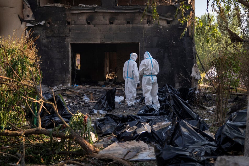 Rettungskräfte untersuchen im Dorf Myla in der Region Kiew in der Ukraine die Leichen von Zivilisten, die bei dem russischen Luftangriff ums Leben gekommen sind.