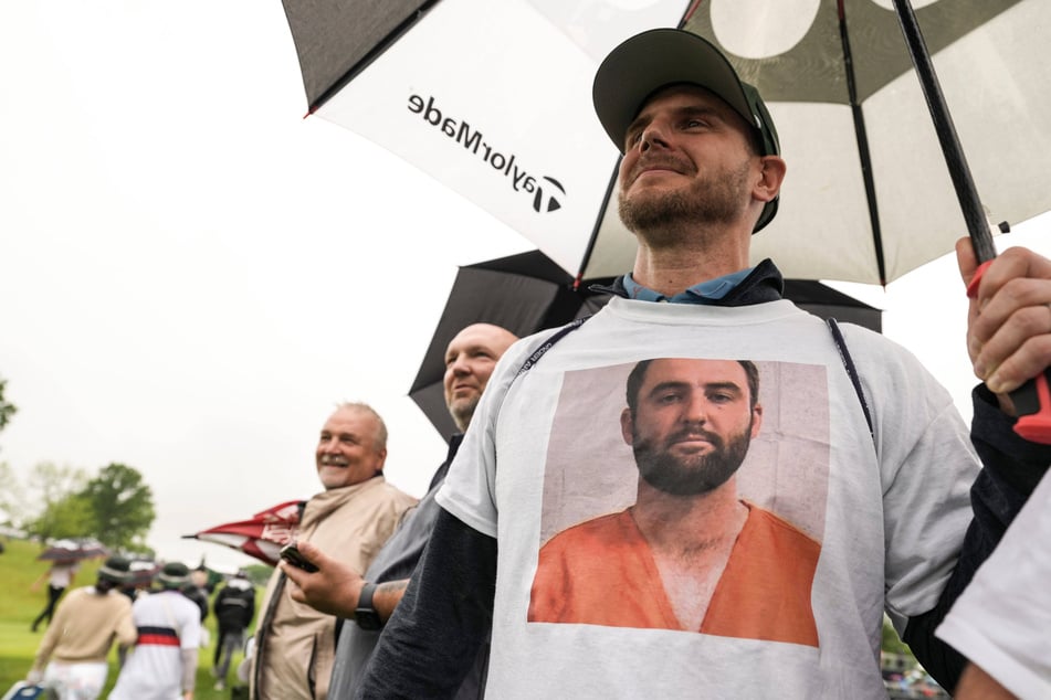 Fans cheered as Scheffler walked through the rain onto the par-5 10th tee after his arrest early Friday morning.