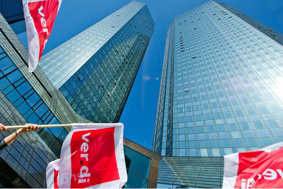 Verdi-Fahnen vor den Türmen der Deutschen Bank in Frankfurt am Main: Die Mitarbeiter mehrerer öffentlicher und privater Banken sind am Freitag zum Warnstreik aufgerufen. (Archivbild)