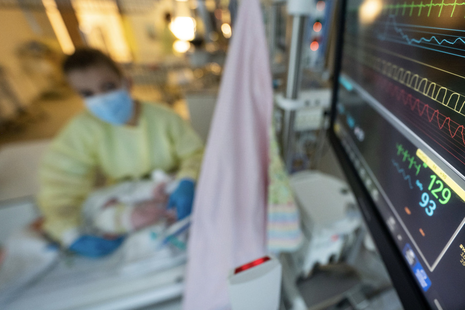 Eine Intensivpflegerin versorgt auf einer Kinder-Intensivstation einen am Respiratorischen Synzytial-Virus (RS-Virus) erkrankten Patienten, der beatmet wird.