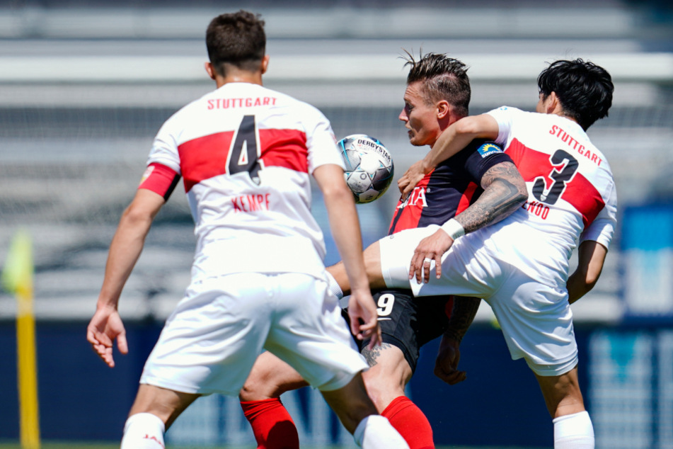 Stuttgarts Marc Oliver Kempf (l-r), Wiesbadens Manuel Schäffler und Stuttgarts Wataru Endo kämpfen um den Ball.