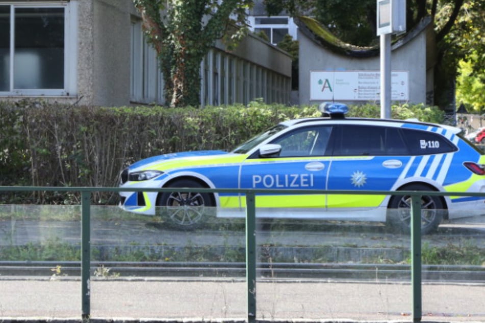 Ein Polizeiauto parkt vor der Berufsschule in Augsburg. Eine Durchsuchung des Gebäudes deckte keine Bedrohung auf.