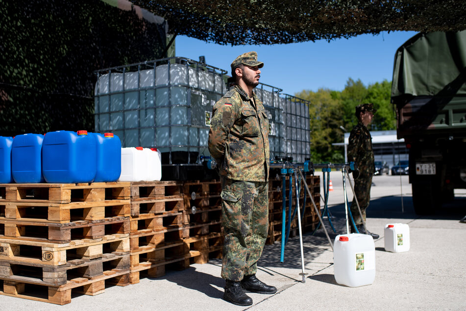 Soldaten des ABC-Abwehrkommandos stehen auf dem Gelände der Universität der Bundeswehr an einer Abfüllanlage für Desinfektionsmittel. An der Universität wird in großen Mengen Flächendesinfektionsmittel produziert, um öffentliche Großflächen vom Coronavirus zu befreien.