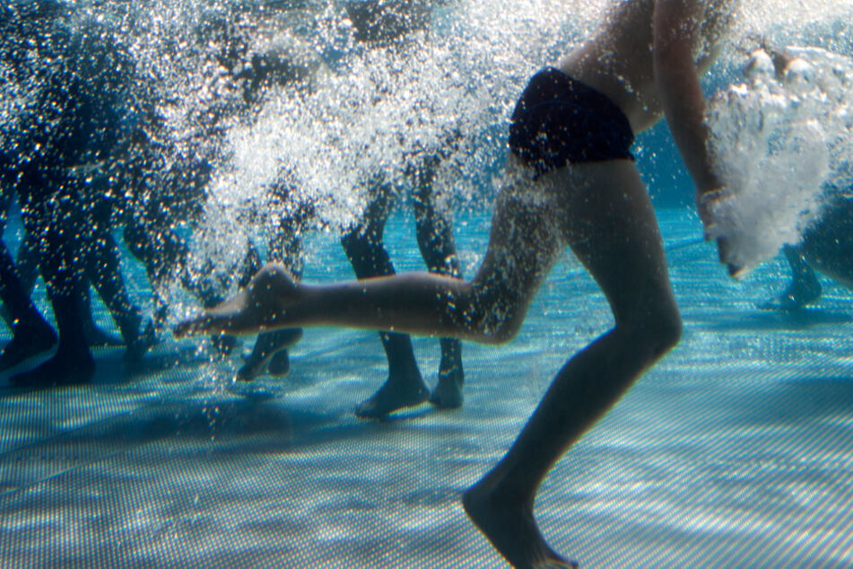Das Unterwasser-Bild zeigt spielende Kinder in einem Freibad.