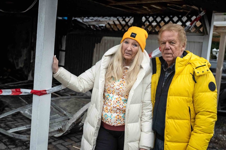 Judith (70) und Mel (79) stehen vor ihrer Garage, in der Anfang des Jahres ein Feuer ausgebrochen war.
