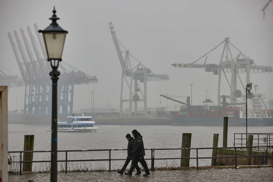 Spaziergänger gehen am Hamburger Hafen entlang. Die Inzidenz in der Hansestadt ist erneut gestiegen.