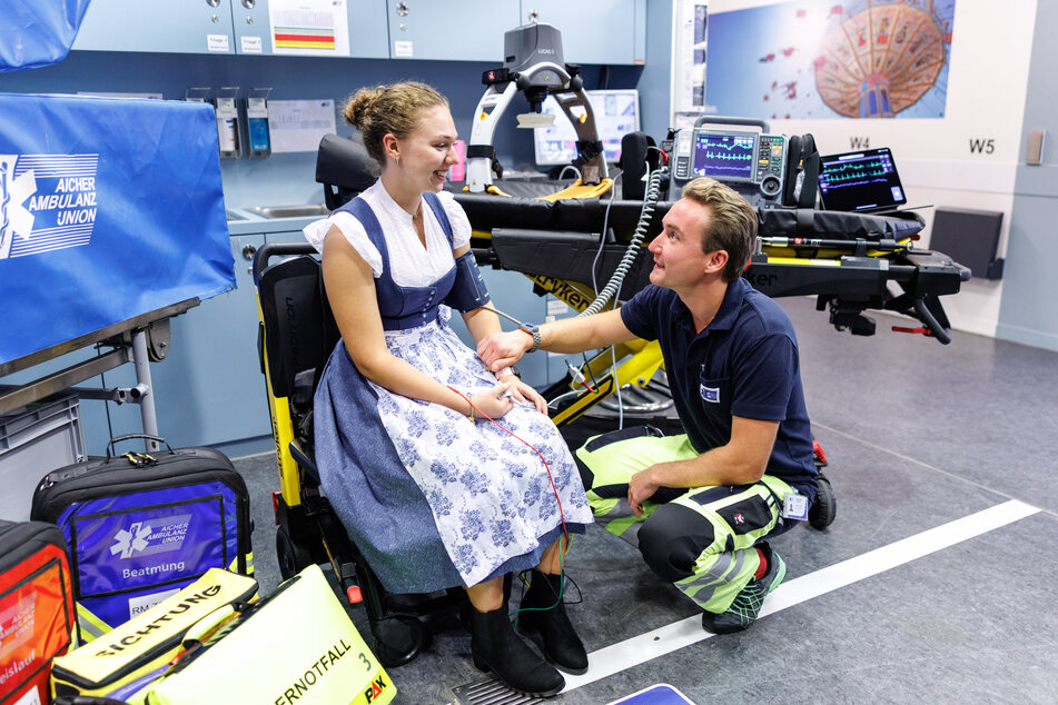 Maximilian Pfandl (r.), Leiter Einsatzbetrieb der Aicher Ambulanz Union, bei einer Führung durch die Wiesn-Station.